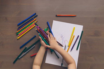 Fototapeta na wymiar little boy draws with colored pencils