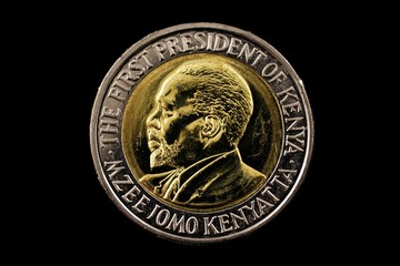 A super close up image of a kenyan twenty shilling coin isolated on a black background