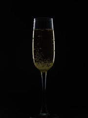 Glass with champagne on a black background.