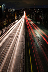 Light trails lead down the highway to the Seattle city skyline at night