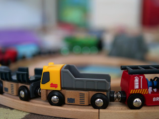 Wooden train toy in colorful child bedroom with truck