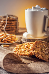 Winter autumn still life  homemade recipe honey ginger oatmeal cookie and bagel, cocoa cup coffee with marshmallow on wooden table kitchen