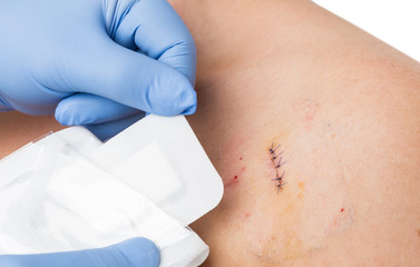 Doctor hands patching stitched surgery with new sterile bandage