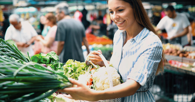 Picture of woman at marketplace buying vegetables