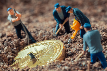 macro miner figurines digging ground to uncover big shiny bitcoin