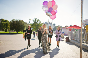 Obraz premium Five girls wear on black walking with balloons at hen party.