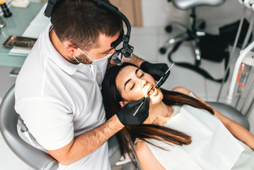 Obraz premium Dentist working in dental clinic with female patient in the chair