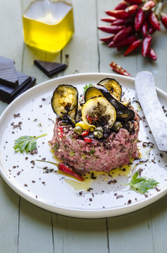 Beef tartara with fried eggplant, capers, chili pepper and dark chocolate