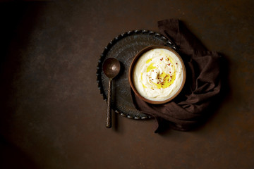 Mashed Cauliflower dish on dark brown background