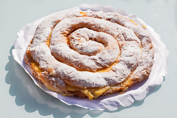 Ensaimada with cream, spiral shaped pastry typical of Majorca, Spain
