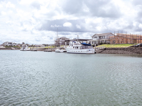 Waterfront houses with private boat jetties under construction at Marsden Cove, near Whangarei, Northland, New Zealand, NZ