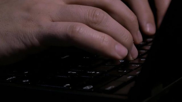Close up of Hacker hands typing on keyboard

