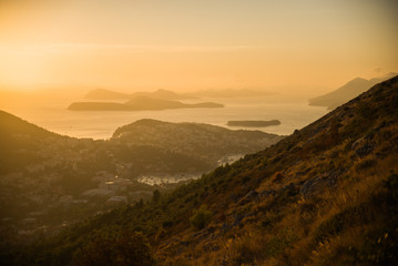 Sunset on the Adriatic sea with layers mountains on the horizon. Beautiful panoramic view of Dubrovnik, Croatia.