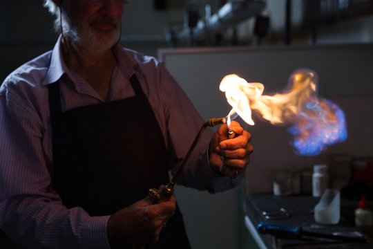 Goldsmith using welding torch in workshop