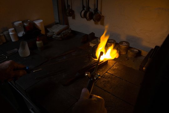 Goldsmith hands using welding torch in workshop