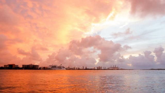 Time-lapse of Aerial Drone View Of Miami Loading Cranes By The Ocean With Ominous Clouds With The Sunrise Peeking Through