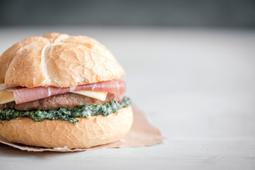 Beef burgers with spinach and prosciutto,close up and blank space