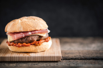 Beef burgers with ajvar and prosciutto,blank space and selective focus