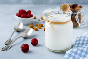 Fresh natural yogurt in a glass jar on  gray concrete or stone background.Healthy food.for...