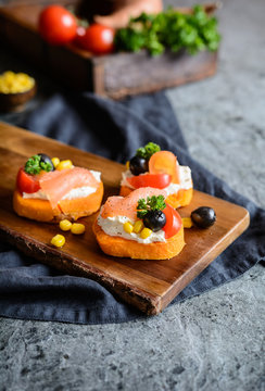 Sweet potato slices topped with cream cheese, smoked salmon, olives and corn