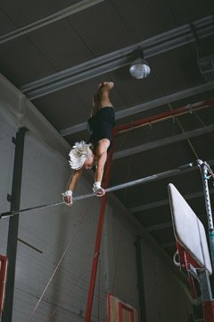 Male gymnast practicing gymnastics on the horizontal bar