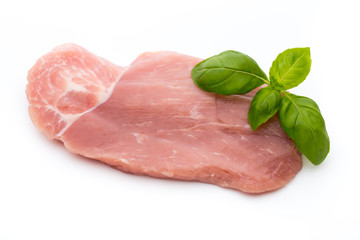 Fresh pork fillet with basil on a white background.