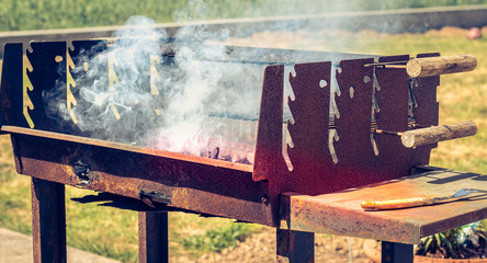 an old rusty steaming barbecue when lighting in garden