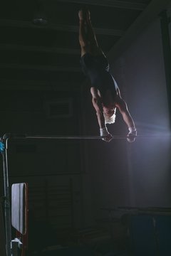 Male gymnast practicing gymnastics on the horizontal bar