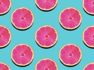 Foto op Plexiglas Grapefruit in plat lag Fruitig patroon van grapefruit met roze vruchtvlees op een turquoise achtergrond Bovenaanzicht Modern plat lag fotopatroon in pop-artstijl © Picture Store