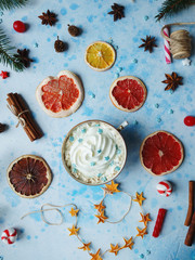 Fototapeta na wymiar Homemade cocoa or hot chocolate, dried oranges, fir tree, cinnamon, candies on blue concrete background