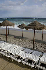 empty beach with straw umbrellas and beach chair