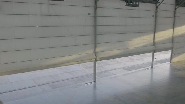 Arplane hangar with doors shut. Shutter or roller door in airport hangar opens and plane background