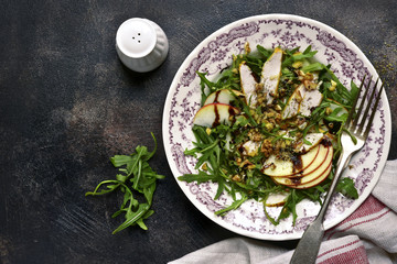 Salad with arugula leaves,roasted chicken,apple and walnut.Top view.