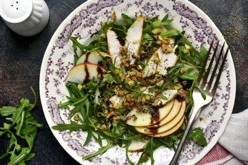 Salad with arugula leaves,roasted chicken,apple and walnut.Top view.