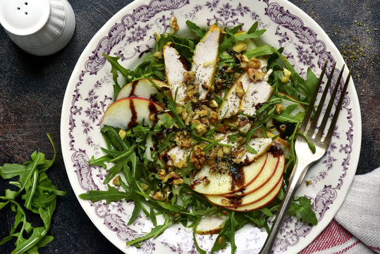 Salad with arugula leaves,roasted chicken,apple and walnut.Top view.