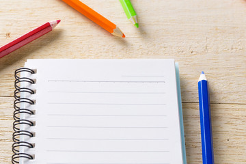 book, diary and crayon on table