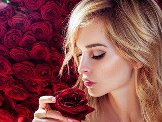 Fresh young fashion model with red lips. Wedding make up. Roses. Flowers background. Spring