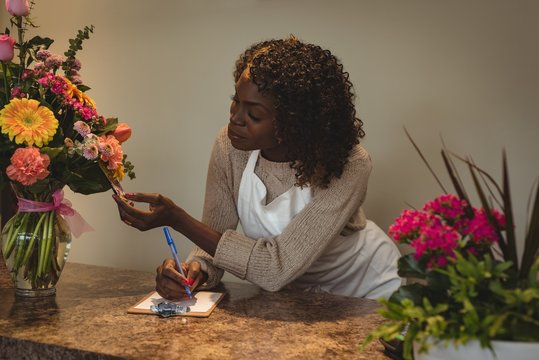Female florist taking order on mobile phone