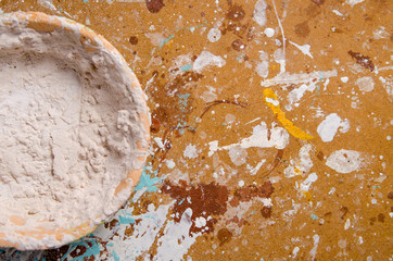 A bowl with dried putty on a hardboard