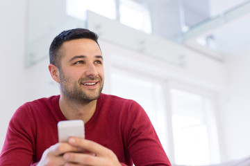 young man using a mobile phone  at home