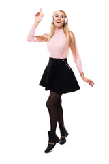 Full length of cheerful young woman listening to music from mobile phone over white background