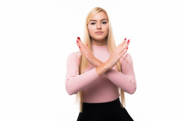 Smiling young woman showing stop gesture, by crossing hands, isolated over white background
