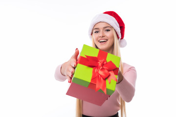 Christmas woman holding giving gift excited pointing. Happy smiling woman in santa hat giving you a present being joyful, fresh and cheerful.
