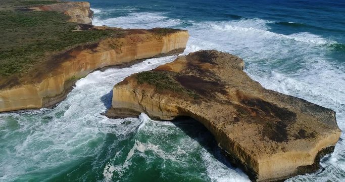 London bridge disconnected limestone rock with arch on Great Ocean road aerial top down panning.
