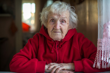 Elderly woman portrait in a bright red jacket.
