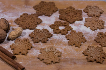 Christmas star-shaped cookies stacked on a wooden board crushed with flour sprinkled