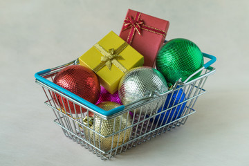 Full of Christmas decoration balls and gift chocolate boxes in miniature basket as Christmas and new year season spending concept