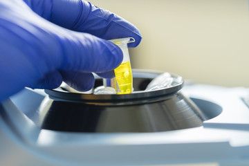 Scientist putting test tube into centrifuge	