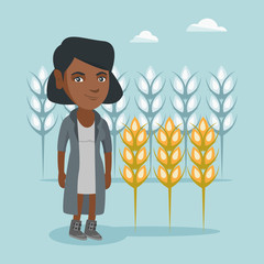 Young african-american rancher standing on the background of wheat field