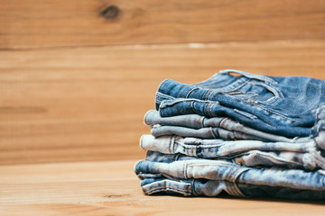 Fashionable clothes. pile of jeans on a wooden background